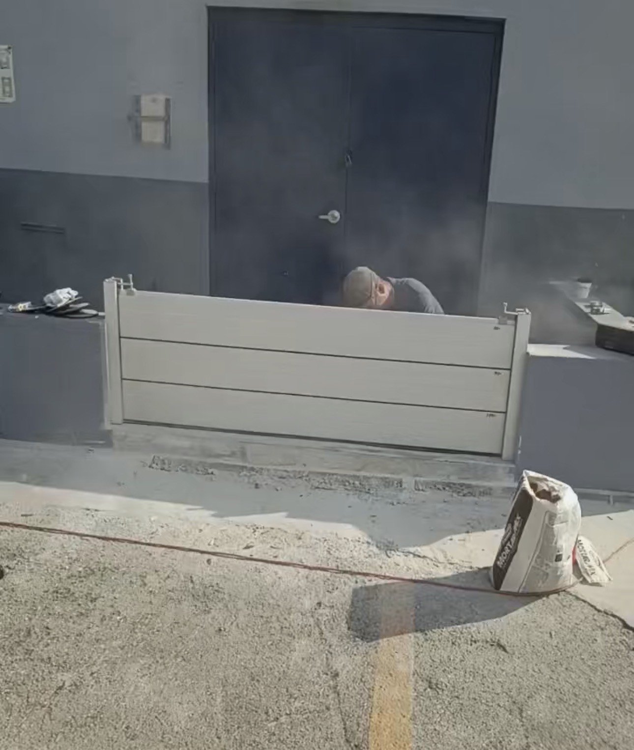 Entrance A in Eric’s Miami Gardens project, showing silver-gray aluminum panels between side channels during installation.