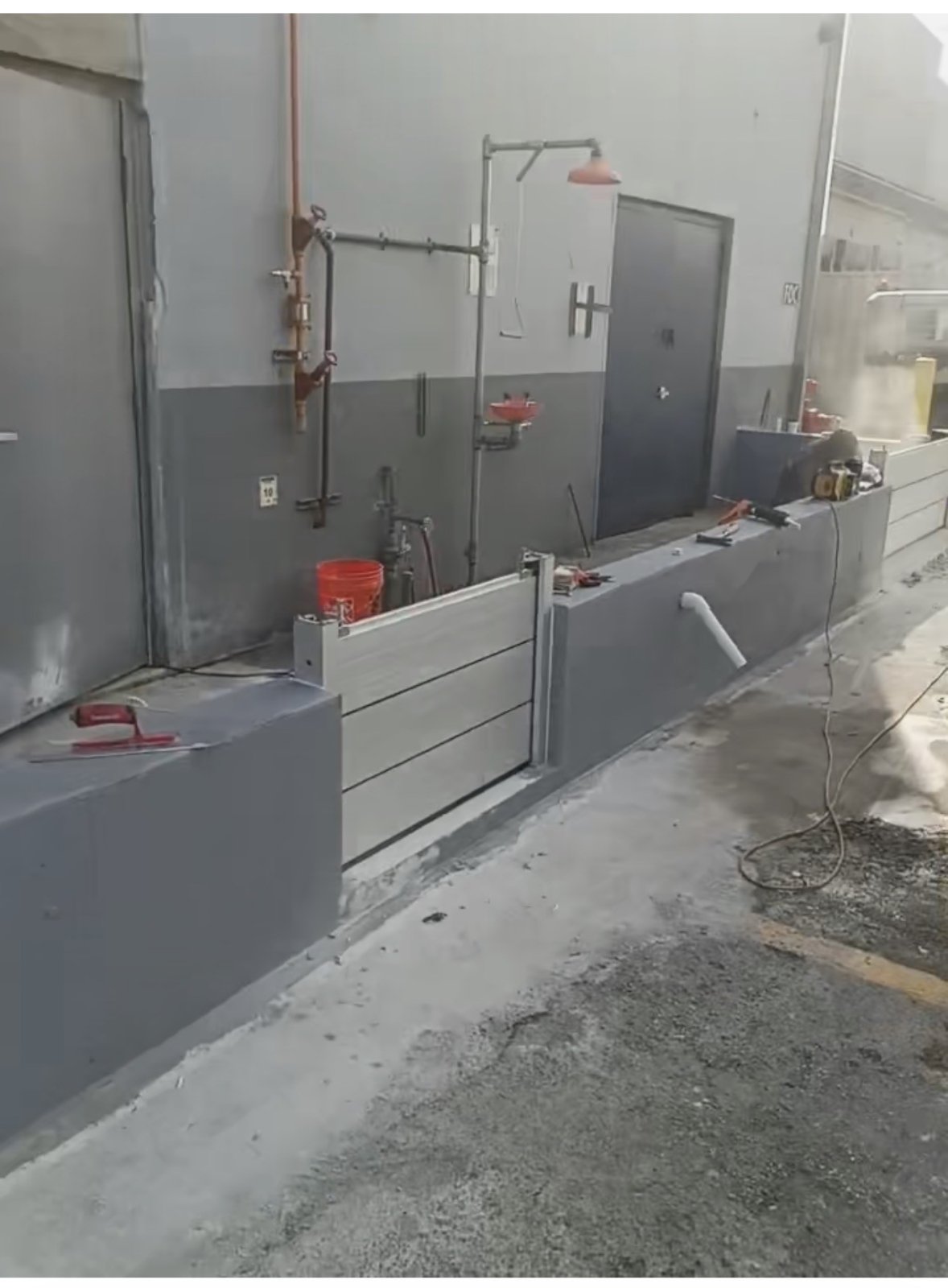 Entrance B in Eric’s Miami Gardens project, showing aluminum panels spanning an opening between low walls.